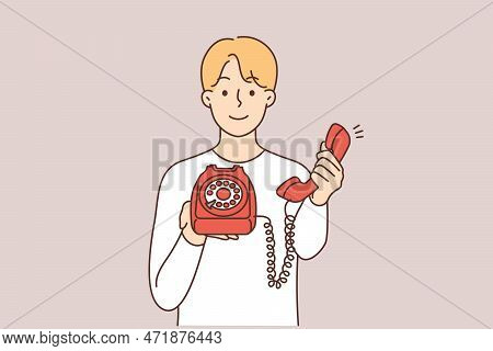 Smiling Man Holding Retro Landline Phone Offer To Make Call. Happy Guy With Corded Telephone Suggest