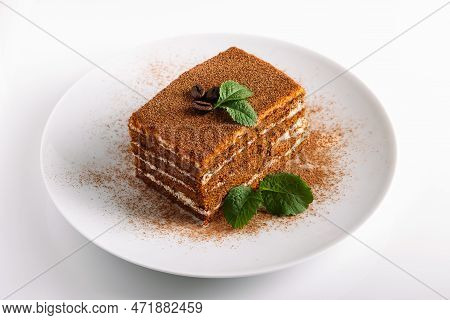 Tiramisu Decorated With Mint On Light Background. Slice Of Coffee Cake On White Plate. Traditional I