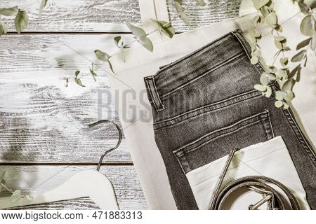 Djinns, T-shirt, Belt On Textile Bag With Hanger On Wooden Background