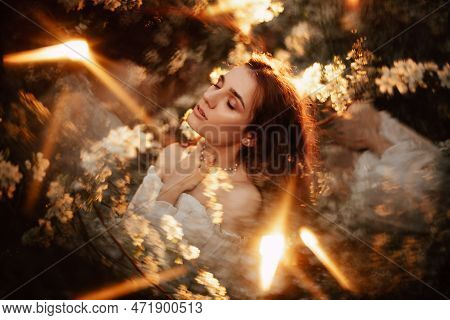 Portrait Of A Romantic Girl, Like A Forest Nymph, In A Blooming Garden With Elements Of Phantasmagor