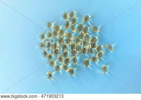 Little Yellow Pills, Capsules, Supplements On Blue Background, Vitamin D, D3 Or Omega 3 In The Sun, 