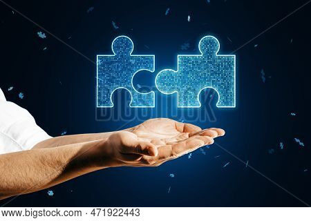 Close Up Of Male Hands Holding Glowing Digital Blue Jigsaw Puzzle Hologram On Dark Blurry Background