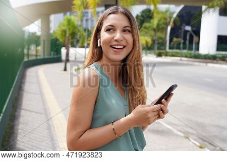 Beautiful Brazilian Girl Using Wireless Earphones To Listening Music In City Street