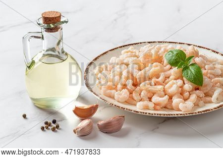Frosen Shrimps On A Plate Over Marble Countertop. Cooked Peeled Prawn Tails, Olive Oil And Garlic Pr
