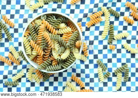 Organic Fusilli Tricolore Spilling On Pink Background