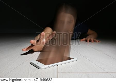 Internet Or Social Media Addiction Concepts. Woman Reaching Out For Smartphone On Floor, Her Face Ab