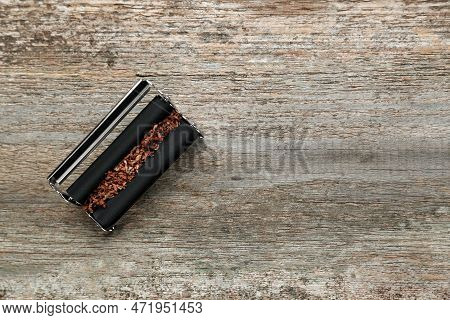 Roller With Tobacco On Old Wooden Table, Top View. Making Hand Rolled Cigarettes