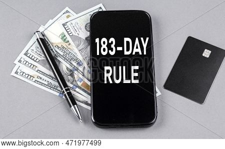 Credit Card And Text 183-day Rule On A Smartphone With Dollars And Pen. Business Concept