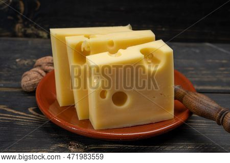 Block Of Swiss Medium-hard Yellow Cheese Emmental Or Emmentaler With Round Holes And Cheese Knife