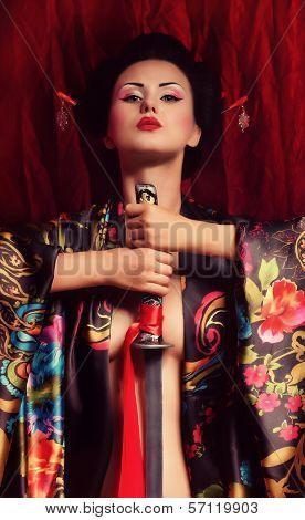 Beautiful geisha in kimono with samurai sword