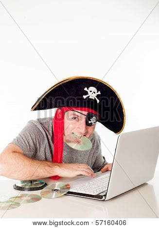 Man In Pirate Hat Downloading Music On A Laptop