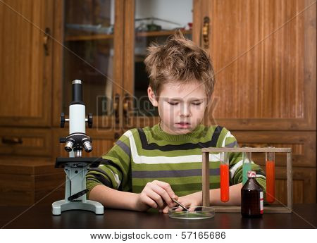 The boy with a microscope and colorful flasks