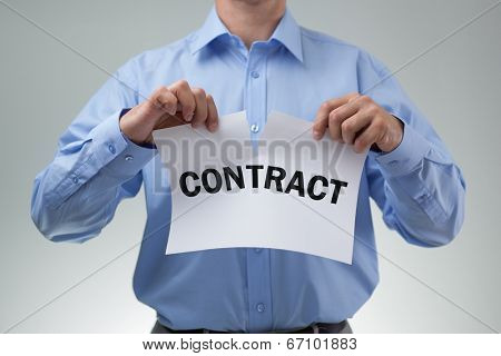 Angry businessman tearing up a document, contract or agreement