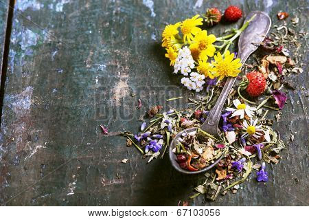 Herbal tea with wild flowers and berry on wooden background - bio food, health and diet concept