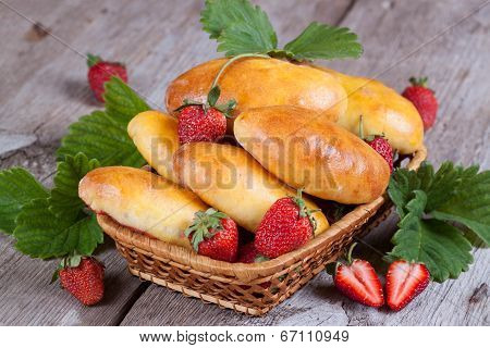 Fresh baked pasties with strawberries in a basket close-up