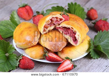 Slice of fresh baked pasties with strawberries on plate close-up