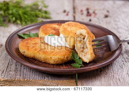 Potato patties with sour cream on the plate, stuffing