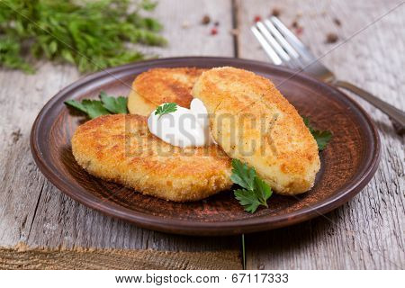 Potato patties with sour cream on a plate