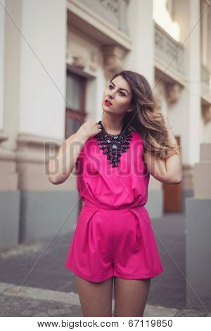 Fashion, Glamorous And Attractive Woman Dressed In A Sexy Sleeveless Pink Jumpsuit With A Hand In He