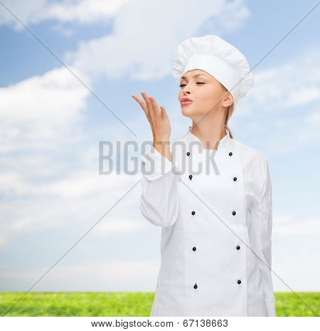 cooking, gesture and food concept - smiling female chef showing delicious gesture