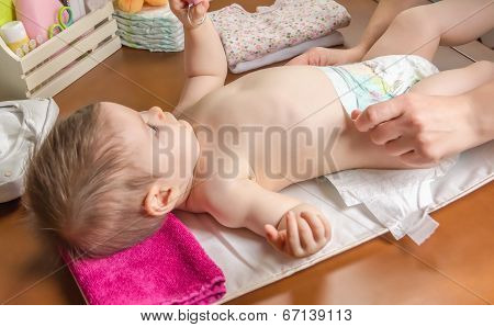 Mother changing diaper of adorable baby