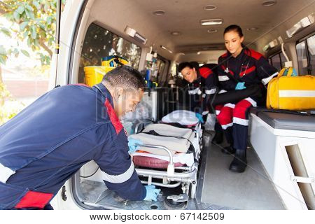 team paramedics taking stretcher out of an ambulance