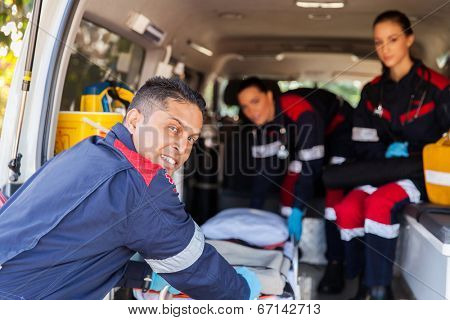 paramedic team pulling stretcher out of an ambulance
