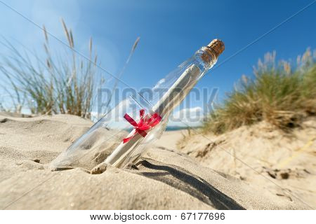 Message in a clear glass bottle washed up on the beach concept for sos, assistance, help and stranded