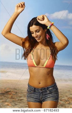 Sexy girl enjoying summer sun on the beach, dancing, smiling happy.