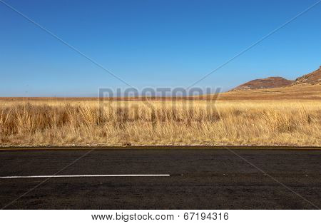 Asphalt Road Disecting Dry Rural Winter Landscape