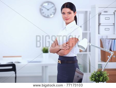 Attractive businesswoman with her arms crossed  standing in office