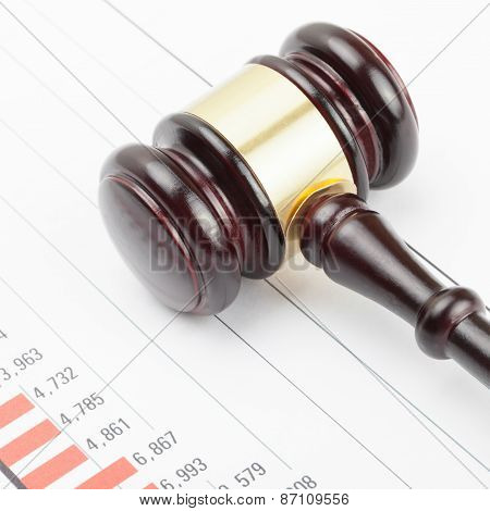 Wooden Judge's Gavel Over Colorful Chart
