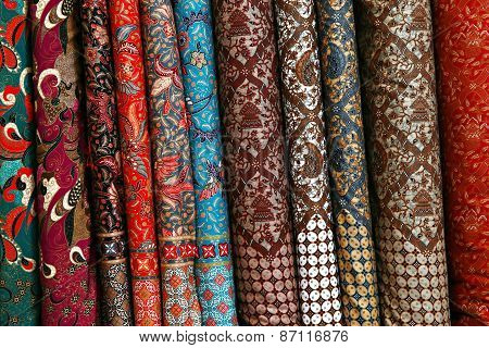 A variety of different bolts of traditional fabric