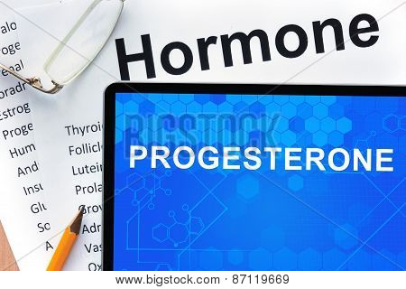 Papers with hormones list and tablet  with word progesterone.