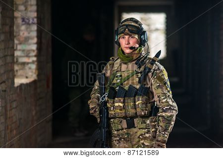 Airsoft strikeball player in uniform. Soldier full gear. Man with a gun is playing airsoft