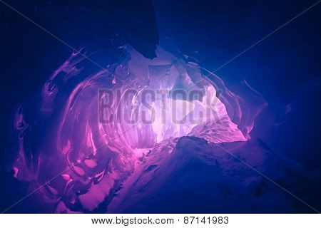 Violet ice cave covered with snow and flooded with light. Antarctica. Vernadsky Research Base.