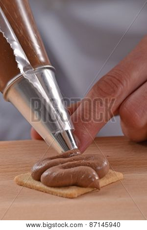 Cook preparing nuts cream cookies.