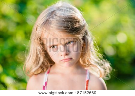 Close-up Portrait Of Capricious Blond Little Girl With Pursed Lips