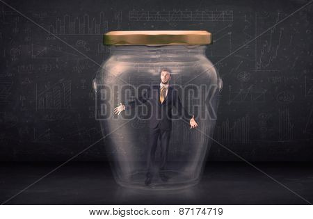 Business man closed into a glass jar concept on background