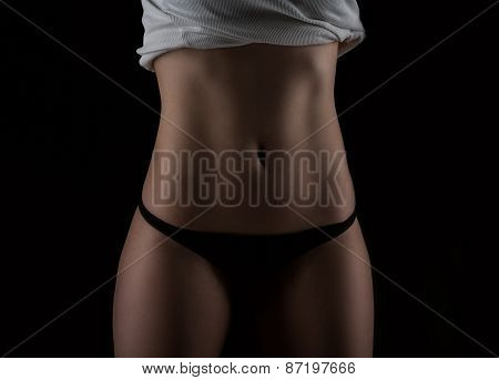 Sexy Slim Fit Woman Body. Muscled Abdomen. Sportswear. Dark Background