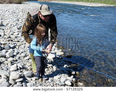 a cheerful father and daughter fishing togheter