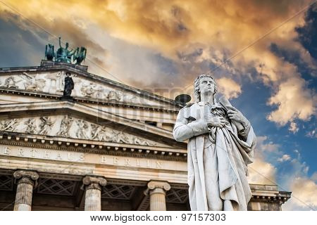 Beautiful squares in Berlin, the Gendarmenmarkt, marble statue of German poet Friedrich Schiller at sunset