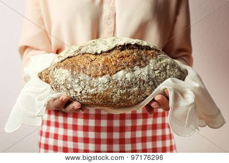 Woman holding tasty fresh bread, close up