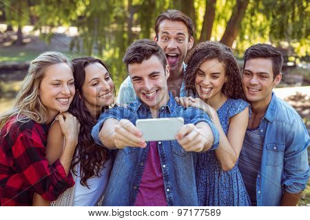 Happy friends taking a selfie on parkland