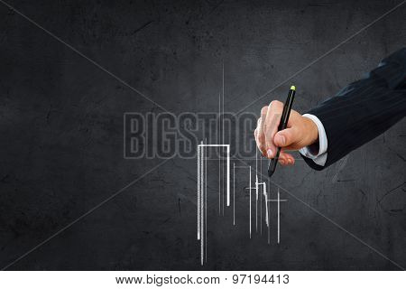 Close up of hand drawing urban buildings with marker