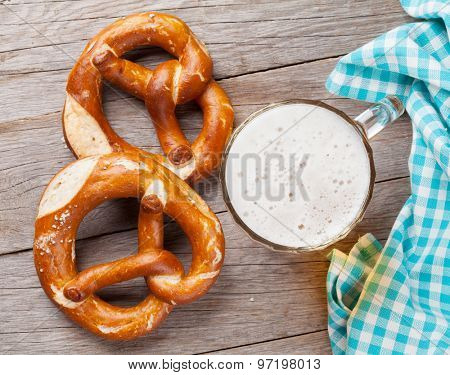 Beer mug and pretzel on wooden table. Top view