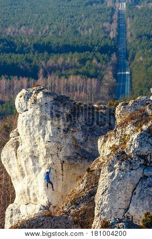 Poland, Podlesice - March 04, 2017: Rock Climber In Blue Shirt Climbing In Gora Zborow, Poland