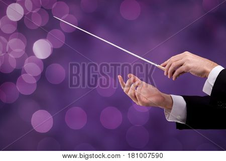Male orchestra conductor hands with gesture, one with baton. Leadership and manager concepts.