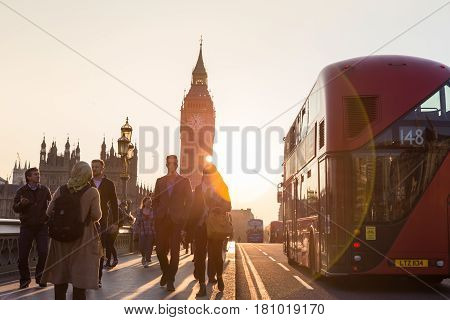 London, UK - April 7, 2015: Traffic and pedestrians passing on Westminster Bridge in sunset on 7th of April, 2017 in London. Big ben and Palace of Westminster aka Houses of Parliament in background.