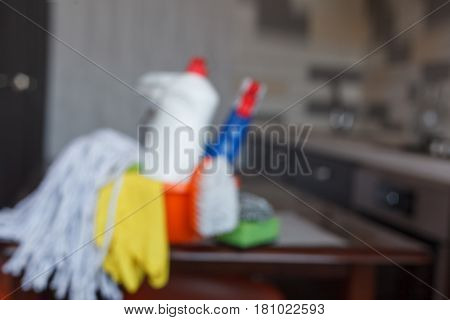 Blurred Cleaning set with products and supplies on kitchen table.